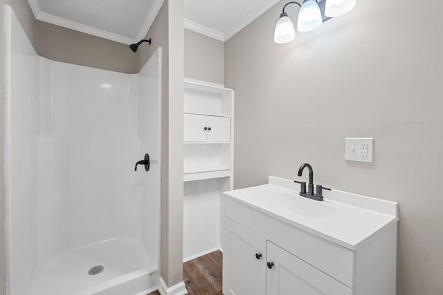 full bath featuring wood finished floors, a stall shower, vanity, and ornamental molding