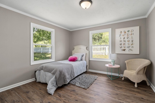 bedroom with crown molding, baseboards, and wood finished floors