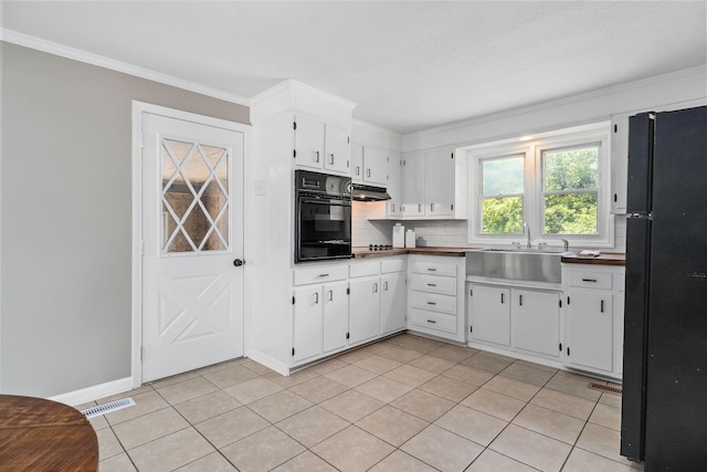 kitchen with visible vents, ornamental molding, decorative backsplash, black appliances, and a sink