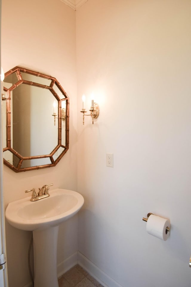 bathroom featuring a sink, baseboards, and tile patterned flooring