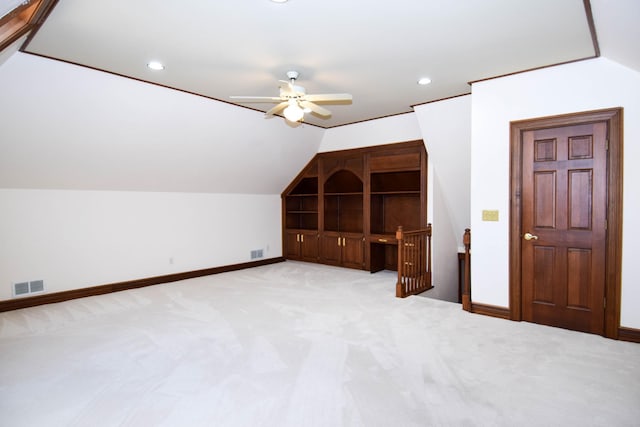 additional living space with vaulted ceiling, light colored carpet, and visible vents