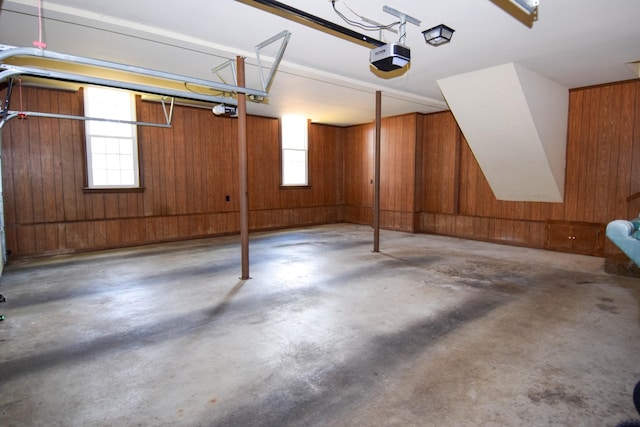 garage featuring wood walls and a garage door opener