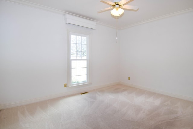 carpeted empty room with a ceiling fan, baseboards, visible vents, and ornamental molding