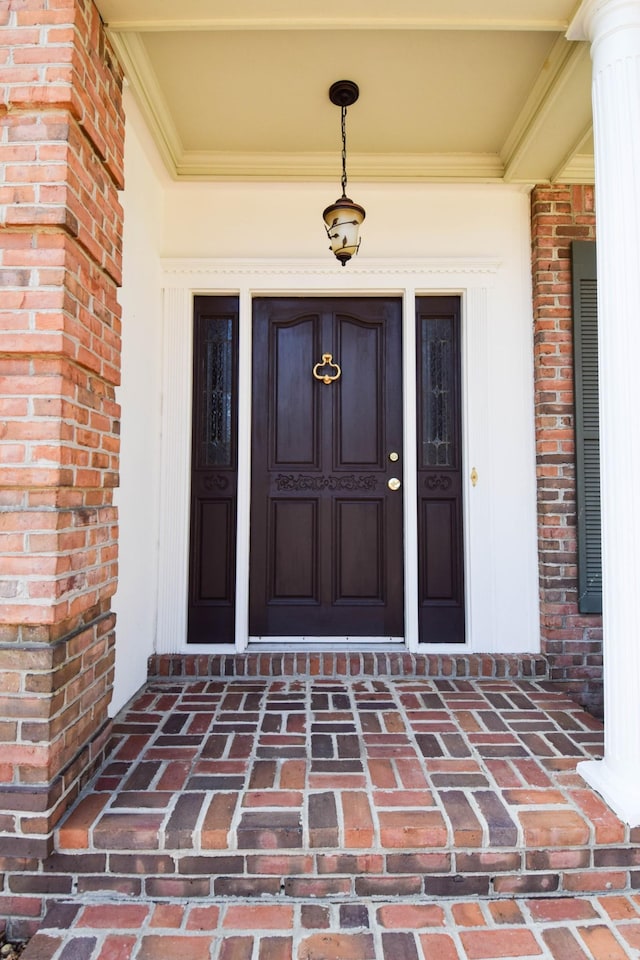 entrance to property featuring brick siding