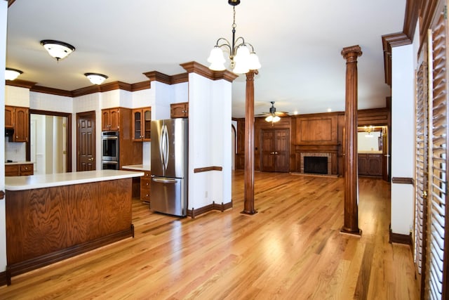 kitchen featuring appliances with stainless steel finishes, light wood-style flooring, ornamental molding, and light countertops