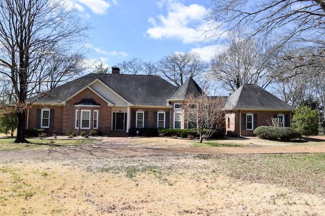 view of front of home with brick siding and a chimney