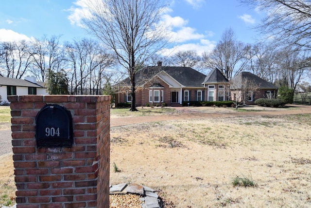 view of front of house with brick siding and a chimney