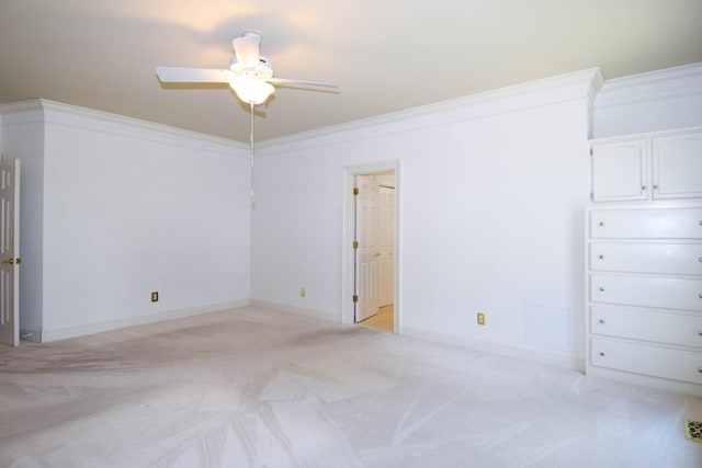 unfurnished bedroom with ceiling fan, light colored carpet, baseboards, and ornamental molding