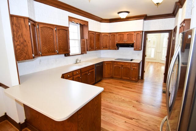 kitchen featuring a peninsula, ornamental molding, black appliances, light countertops, and light wood-style floors