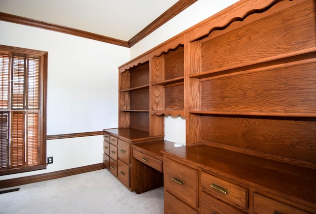 unfurnished office featuring light carpet, built in study area, baseboards, and ornamental molding