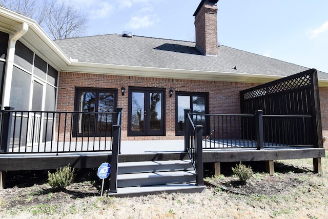 exterior space featuring french doors, brick siding, roof with shingles, and a chimney