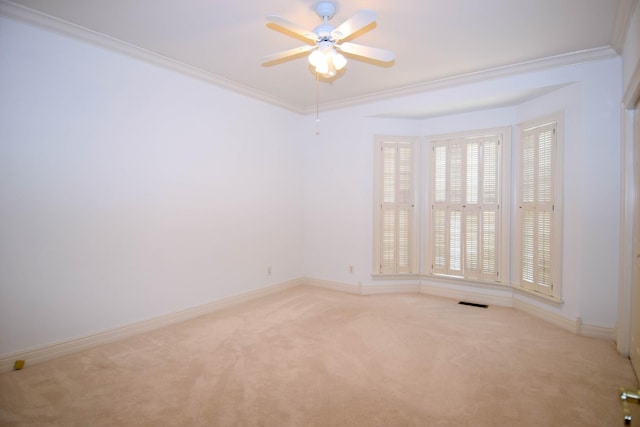 spare room with baseboards, carpet floors, a ceiling fan, and crown molding