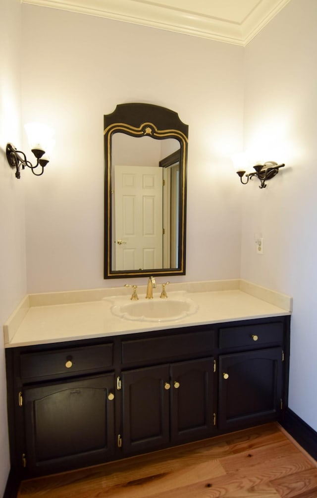 bathroom featuring vanity, crown molding, and wood finished floors