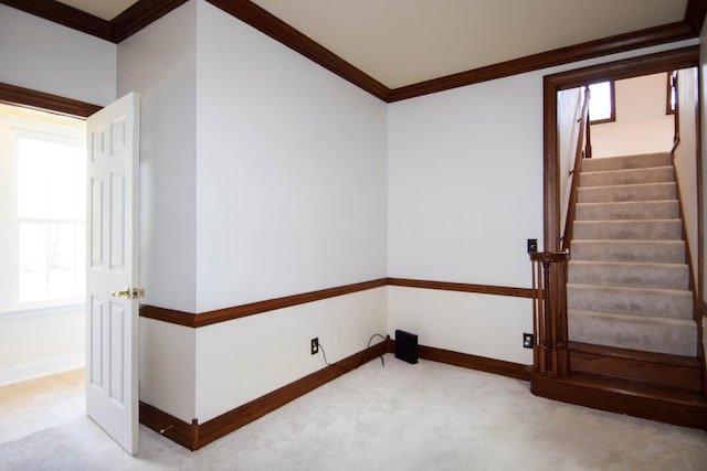 interior space with stairs, baseboards, and ornamental molding