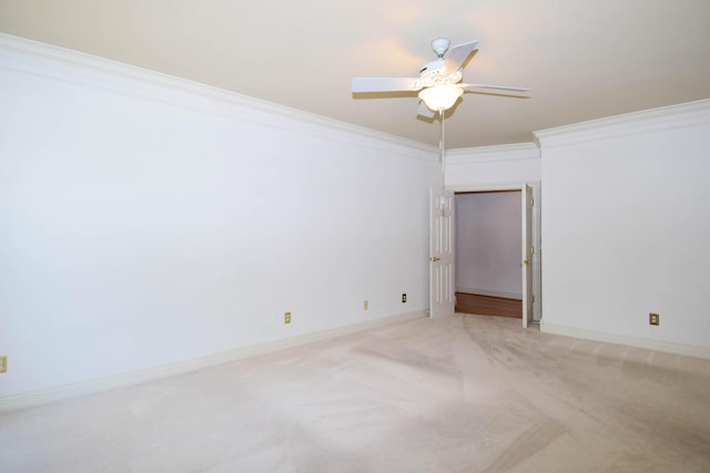 empty room featuring baseboards, light carpet, ceiling fan, and crown molding