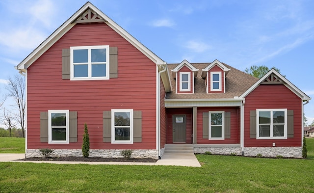 view of front of house with roof with shingles and a front yard