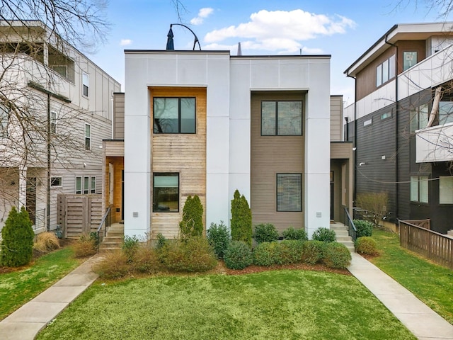 view of front of house with stucco siding and a front lawn