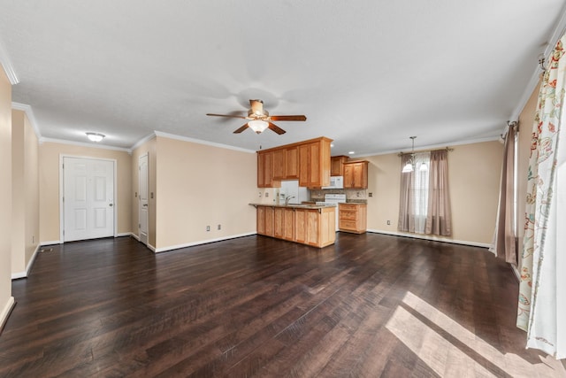 unfurnished living room featuring dark wood finished floors, ceiling fan with notable chandelier, baseboards, and ornamental molding