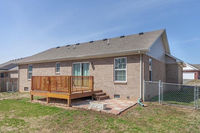 rear view of property with crawl space, a yard, brick siding, and fence