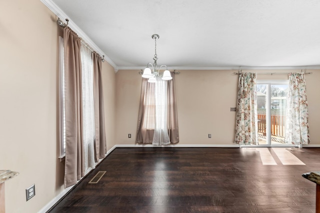 spare room featuring visible vents, ornamental molding, baseboards, and wood finished floors