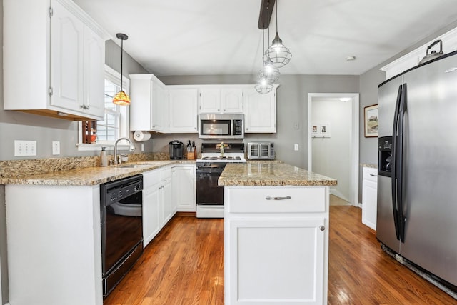 kitchen with a kitchen island, a sink, stainless steel appliances, white cabinets, and light wood-type flooring