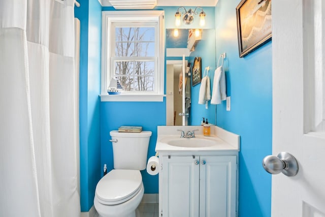 full bath featuring vanity, a shower with shower curtain, and toilet