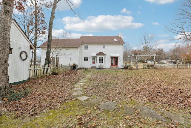 back of property with entry steps, a fenced backyard, a chimney, and a pergola