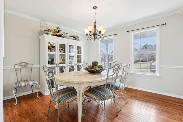 dining space featuring baseboards, a healthy amount of sunlight, wood finished floors, and an inviting chandelier