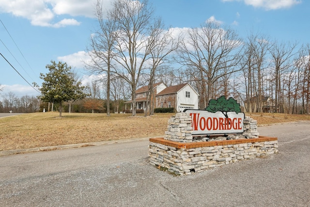 community / neighborhood sign featuring a yard