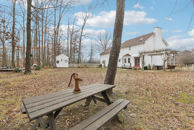 surrounding community featuring fence, an outbuilding, a storage shed, and a pergola