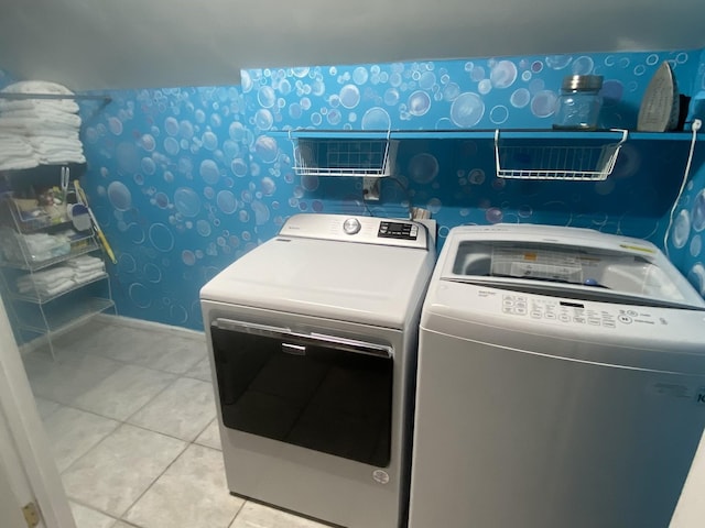 clothes washing area with wallpapered walls, baseboards, laundry area, light tile patterned flooring, and separate washer and dryer