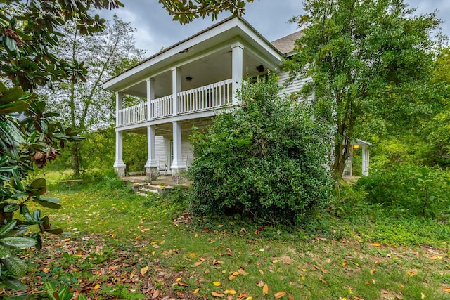 back of house featuring covered porch and a balcony