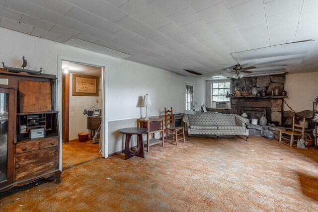 living room featuring a ceiling fan, cooling unit, a fireplace, and carpet