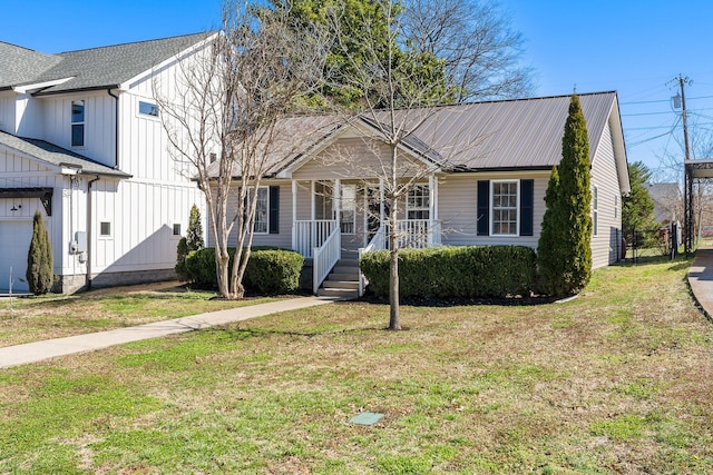 view of front facade featuring covered porch, board and batten siding, metal roof, and a front lawn