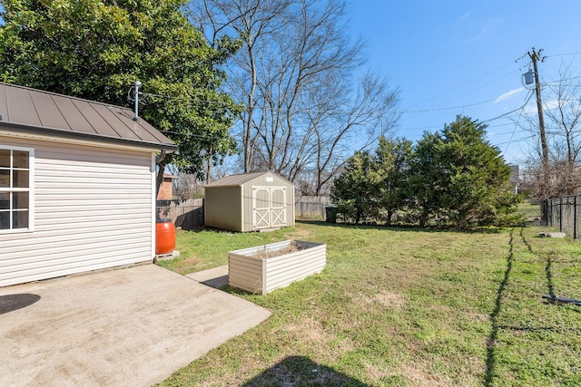 view of yard with a storage unit, a patio, an outbuilding, and a fenced backyard