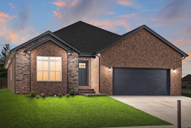 single story home with a lawn, entry steps, concrete driveway, an attached garage, and a shingled roof