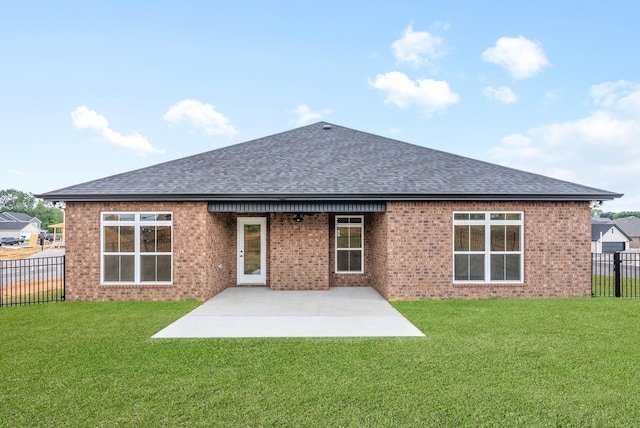 back of house with fence, roof with shingles, a yard, a patio area, and brick siding