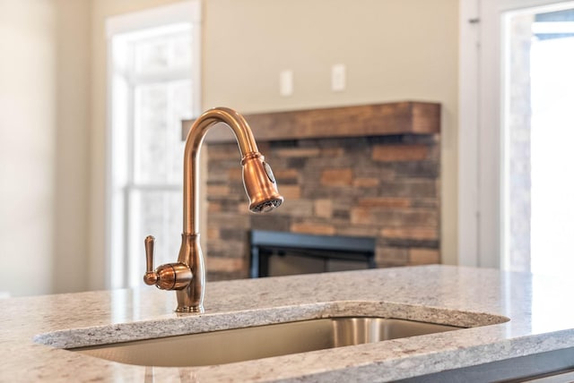 room details featuring light stone countertops and a sink