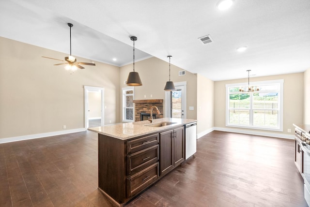 kitchen featuring visible vents, a sink, dark brown cabinetry, open floor plan, and stainless steel dishwasher