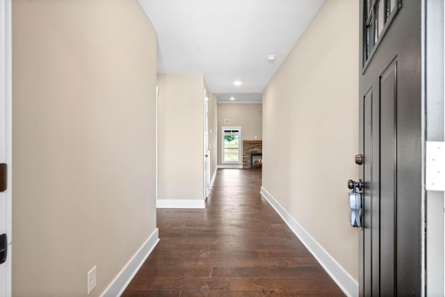 corridor with dark wood-type flooring and baseboards