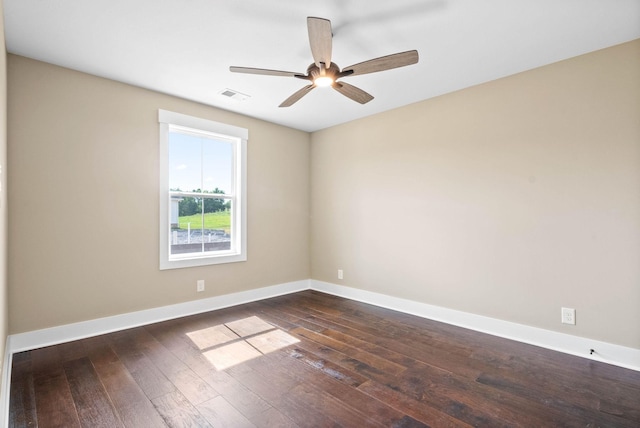 unfurnished room with dark wood-style floors, visible vents, ceiling fan, and baseboards