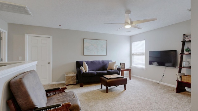 living room featuring visible vents, light carpet, a ceiling fan, a textured ceiling, and baseboards