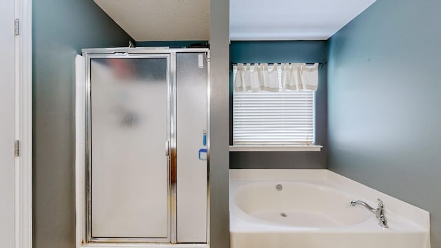 full bathroom with a bath, a stall shower, and a textured ceiling