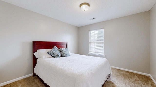 carpeted bedroom with visible vents and baseboards