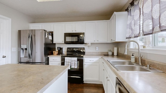 kitchen with black appliances, white cabinets, light countertops, and a sink