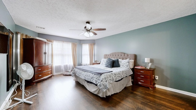 bedroom featuring a ceiling fan, dark wood-type flooring, baseboards, and visible vents