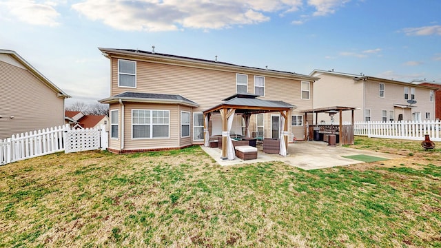 back of property with a gazebo, a yard, a fenced backyard, and a patio area