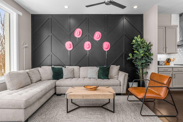 living area featuring a decorative wall, recessed lighting, ceiling fan, and wood finished floors