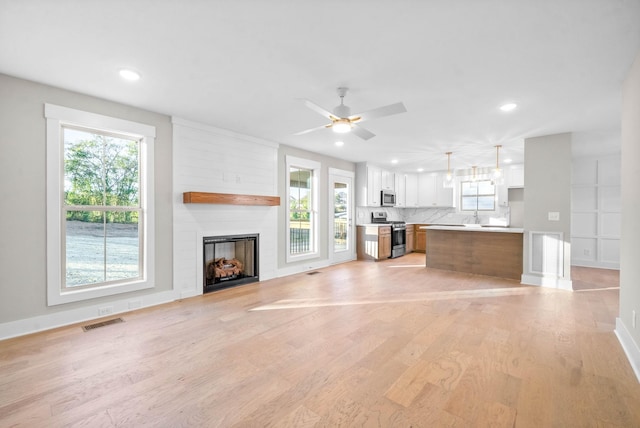 unfurnished living room featuring light wood finished floors, visible vents, a large fireplace, recessed lighting, and a ceiling fan