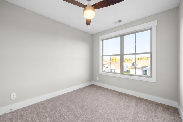 unfurnished room featuring visible vents, carpet floors, baseboards, and ceiling fan